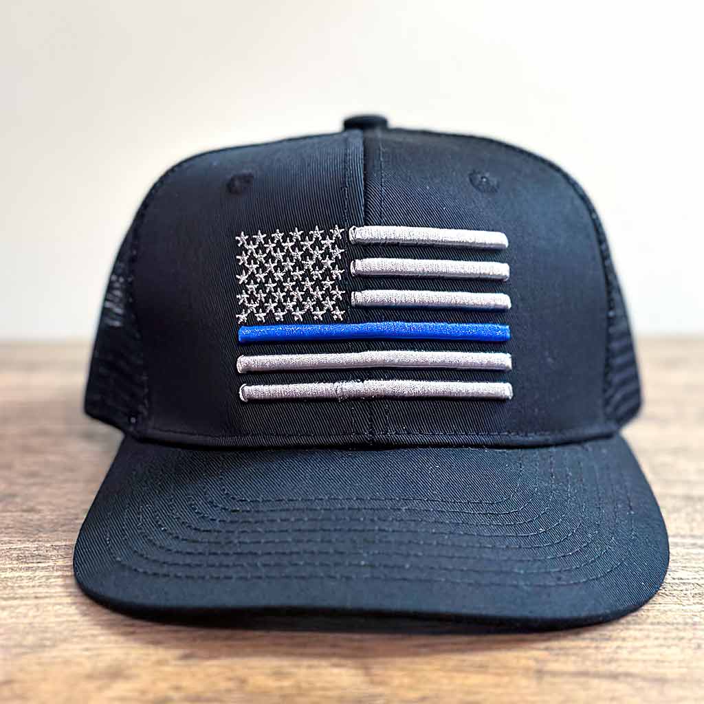 Black hat with an embroidered grey American flag with one blue line