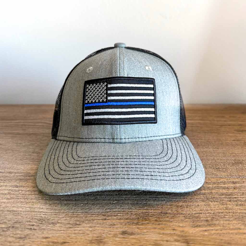 Grey and Black mesh hat with a black and white American Flag with one blue line